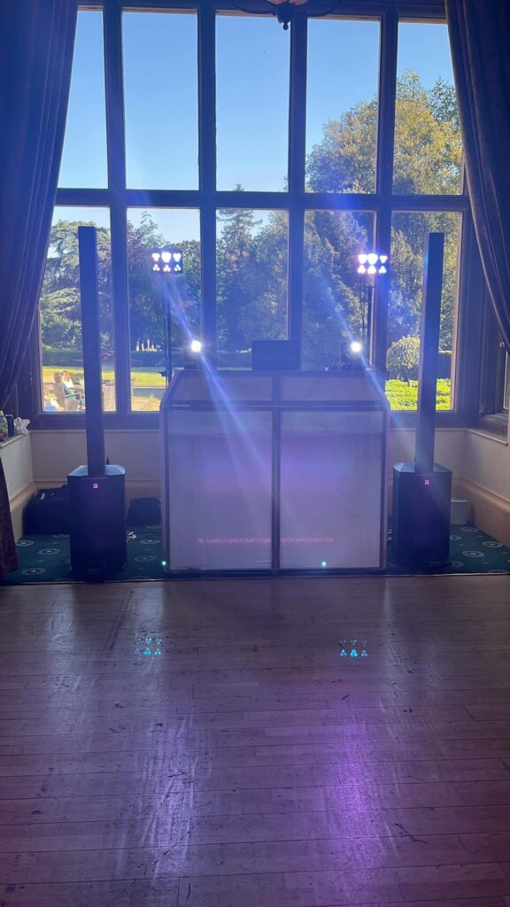     Professional wedding DJ setup with elegant DJ booth, speakers and lighting at a wedding reception